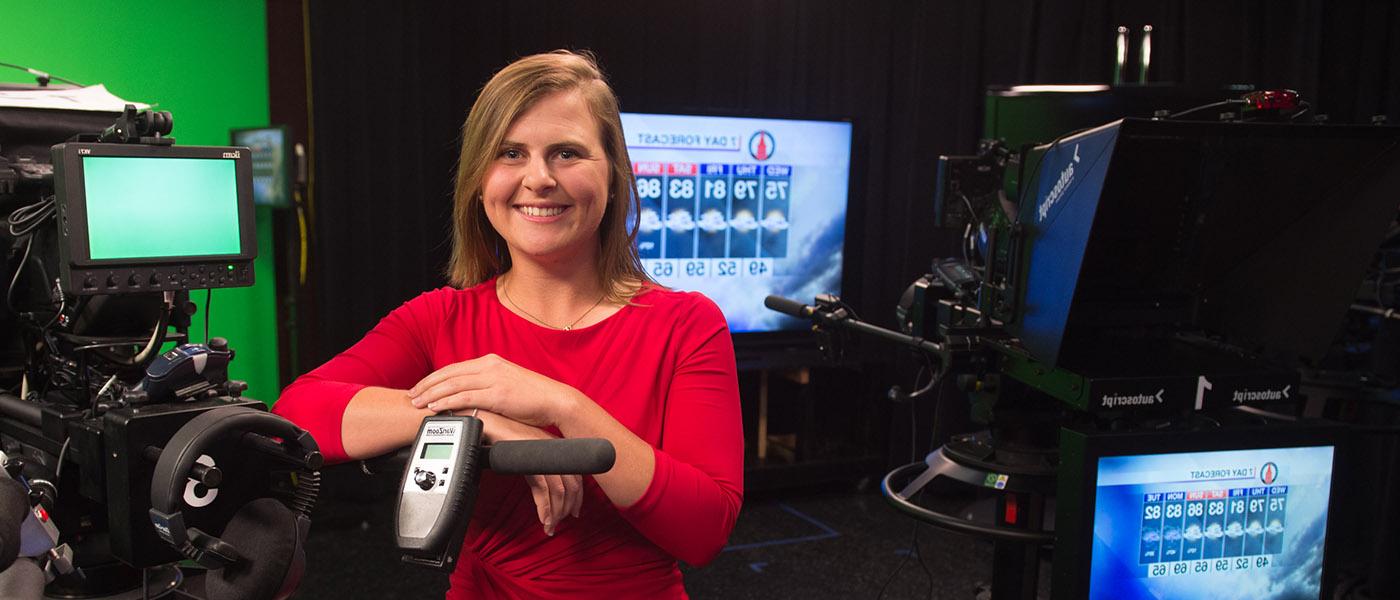 Broadcaster standing next to camera after a 气象学 broadcast in the studio